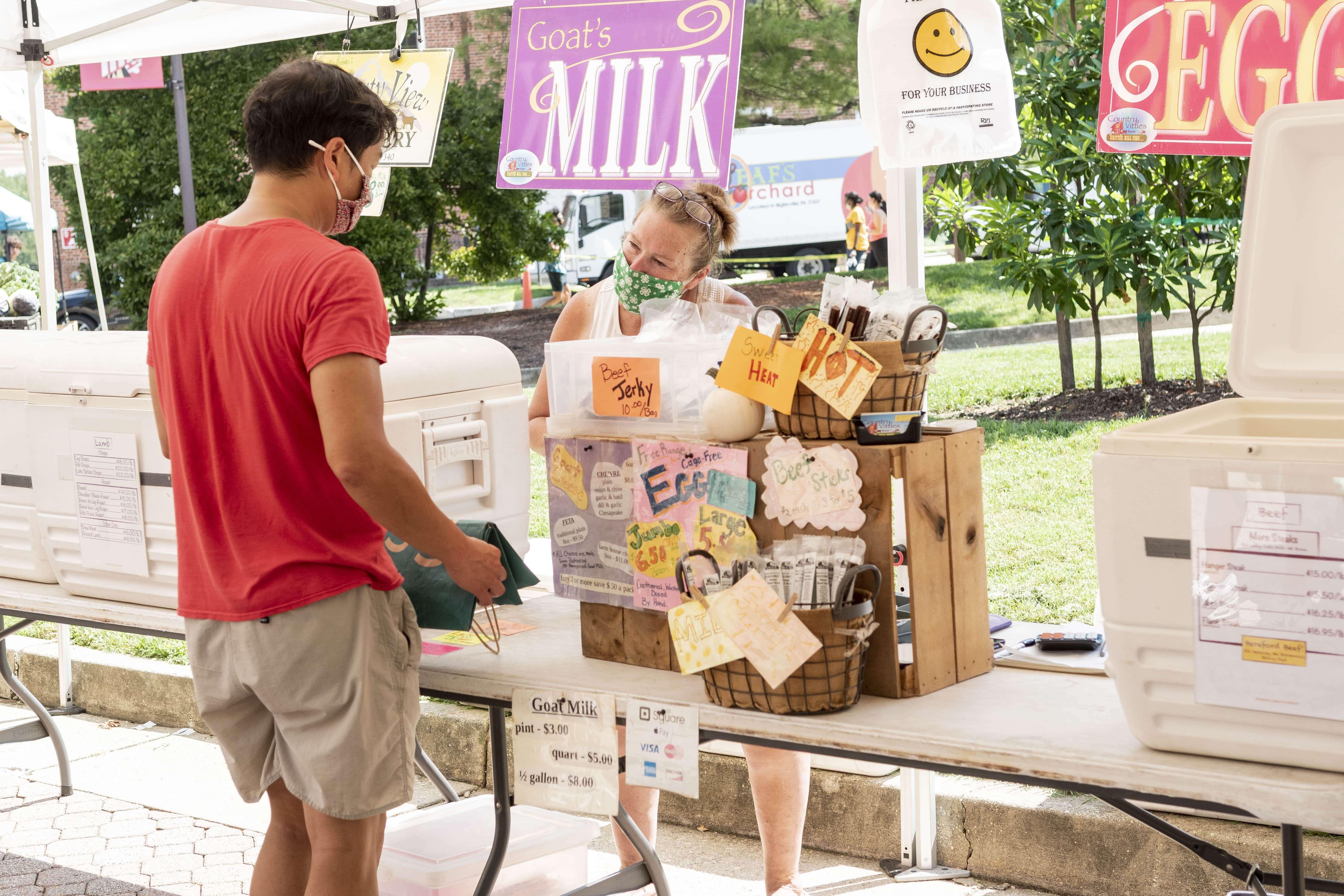 Person buying from farmers market vendor