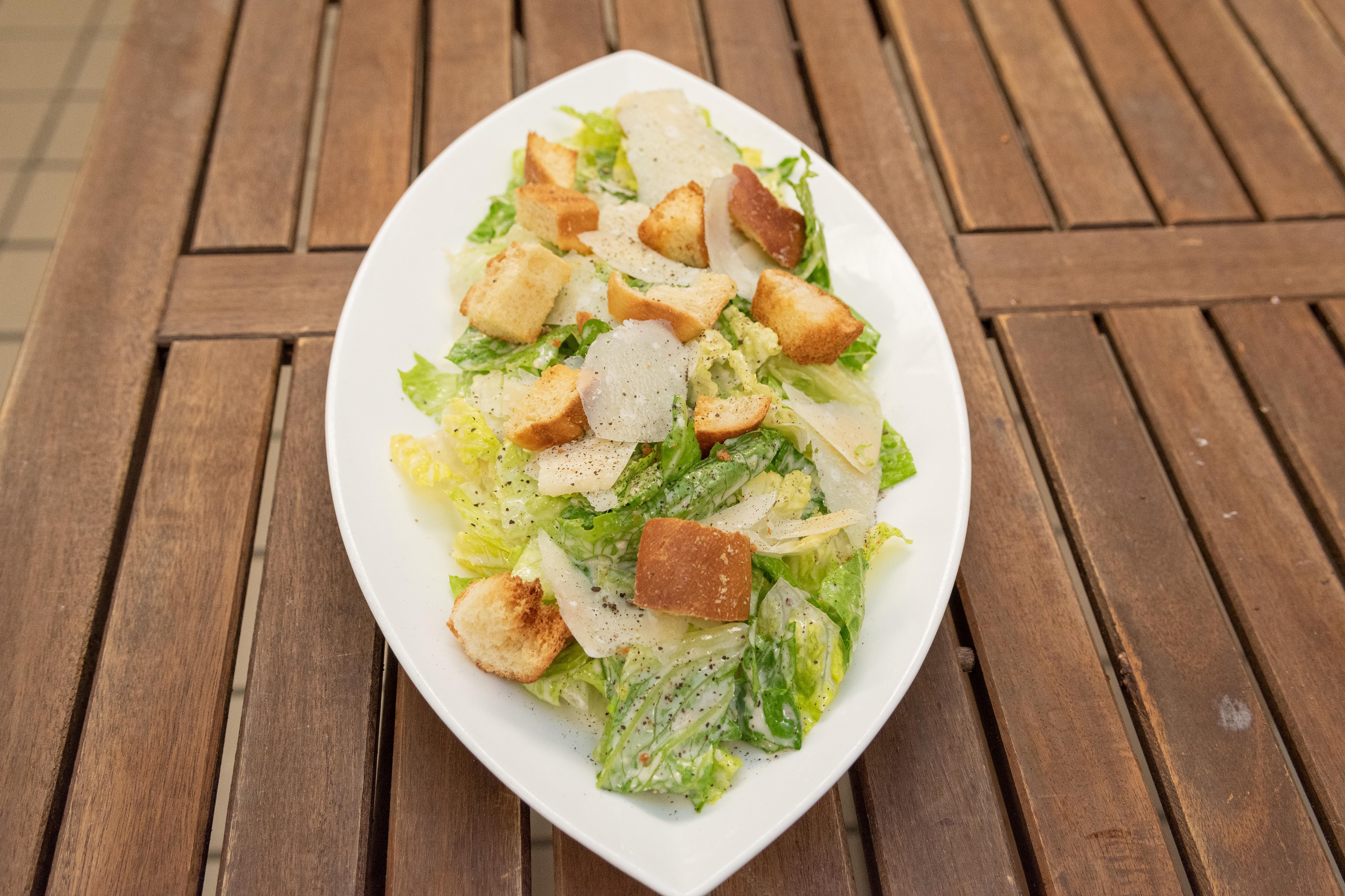 Lettuce salad served on a leaf shaped white dish